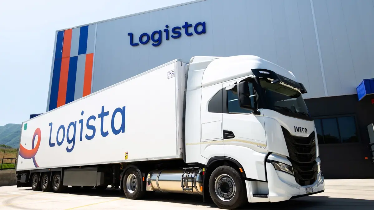 Camión de la compañía española Logista junto a una de sus naves de logística.
