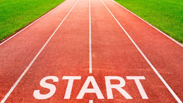Start written on race starting line on of running track of stadium sports field